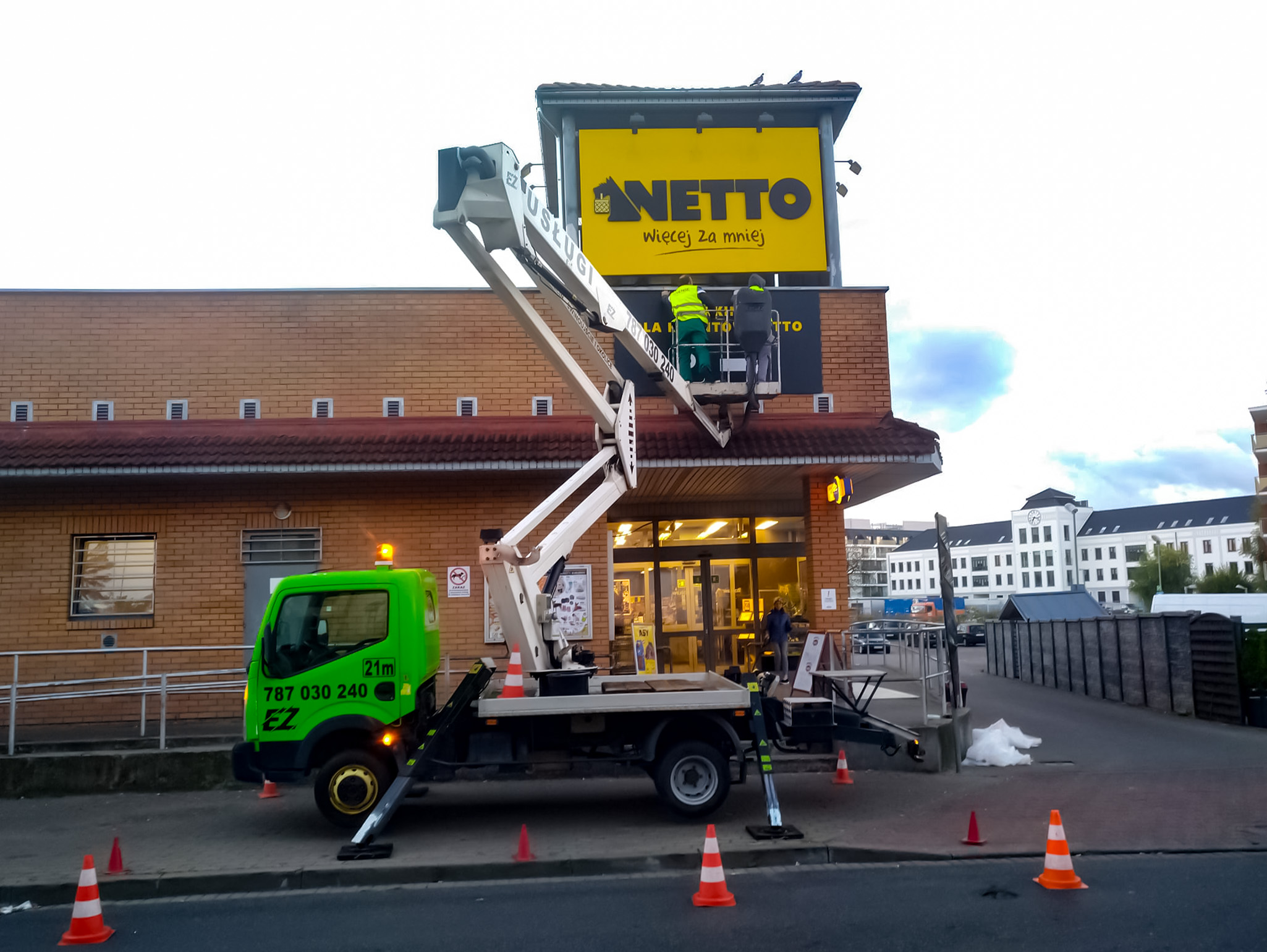 Mycie rynien podnośnikiem koszowym przy sklepie Netto